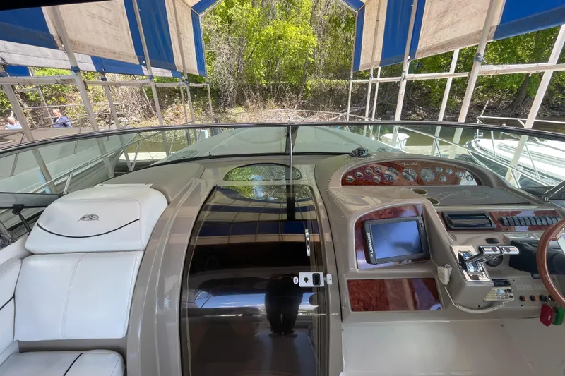 Slide: The Image of 1997 Bayliner 4085 Avanti cockpit with steering wheel, control panel, and white seating under canopy. - 17