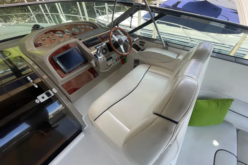 Slide: The Image of 1997 Bayliner 4085 Avanti cockpit with white seating, wood accents, and modern controls. - 18