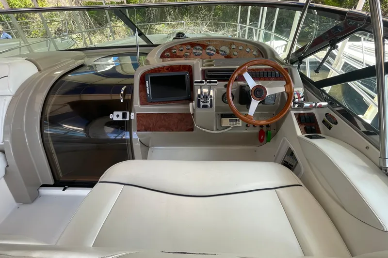 Slide: The Image of 1997 Bayliner 4085 Avanti helm with wooden steering wheel and modern controls. - 19