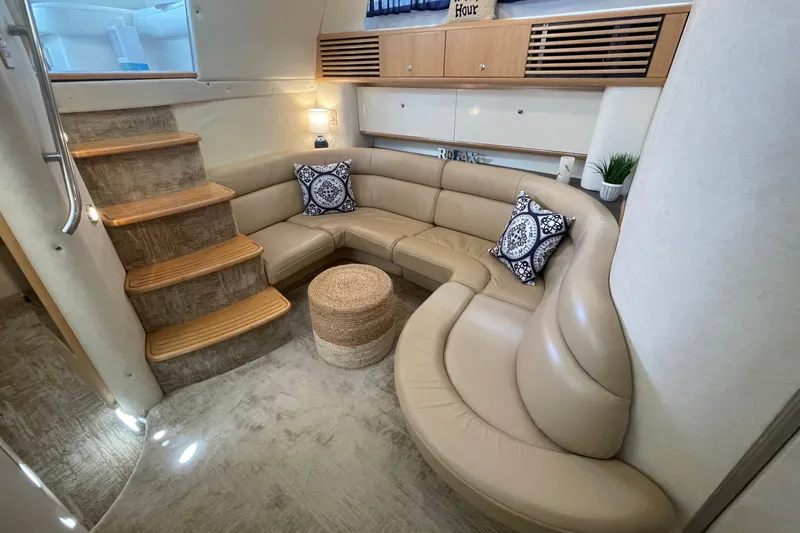 Slide: The Image of Luxurious interior of 1997 Bayliner 4085 Avanti with curved leather seating and decorative pillows. - 23