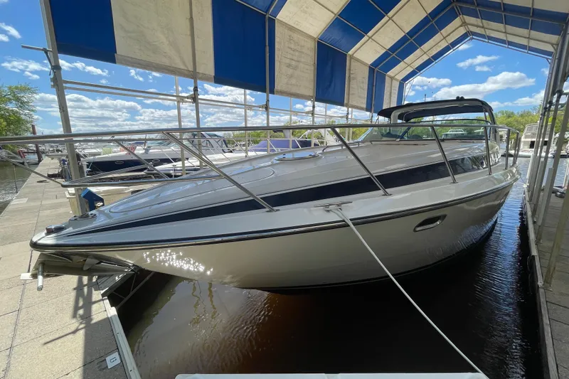 Slide: The Image of 1997 Bayliner 4085 Avanti yacht docked under a canopy on a sunny day. - 3