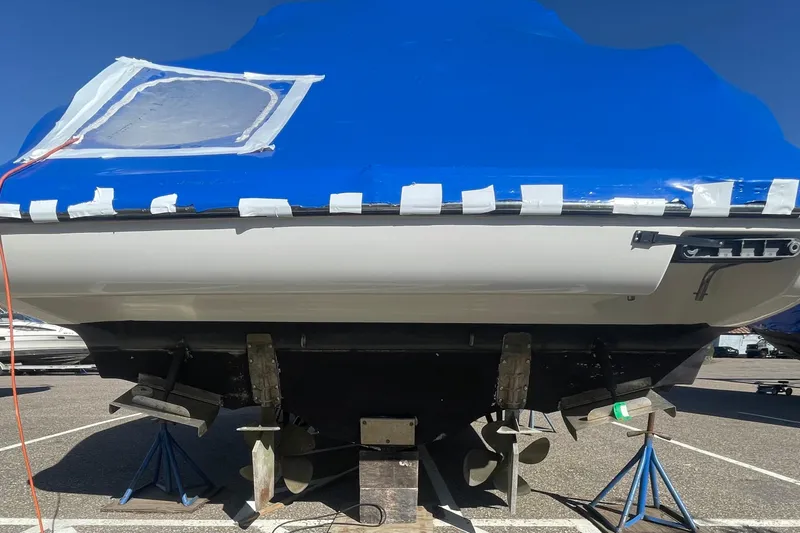 Slide: The Image of 1997 Bayliner 4085 Avanti boat on stands, covered with blue tarp, in a parking lot. - 36