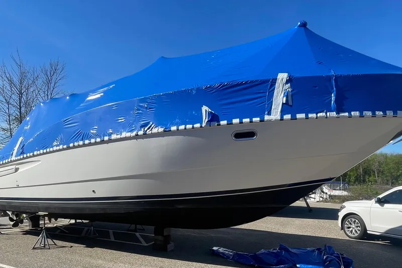 Slide: The Image of 1997 Bayliner 4085 Avanti boat covered with blue tarp, parked outdoors. - 37