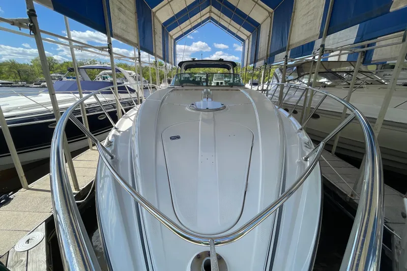 Slide: The Image of 1997 Bayliner 4085 Avanti yacht docked under a canopy, surrounded by other boats. - 4