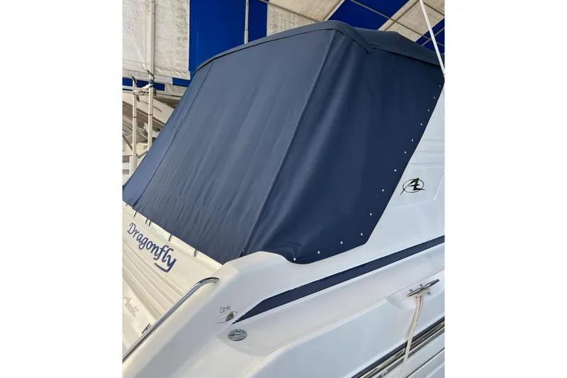 Slide: The Image of 1997 Bayliner 4085 Avanti boat with blue cover, named "Dragonfly," docked in a marina. - 40