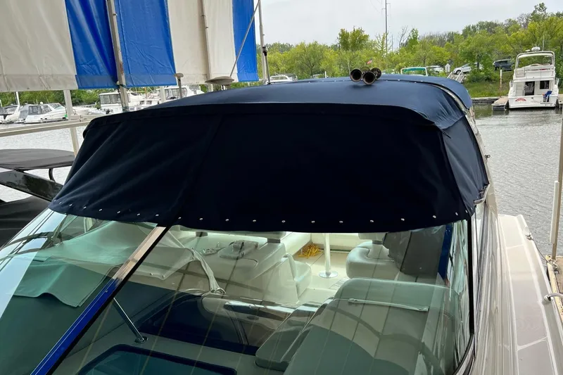Slide: The Image of 1997 Bayliner 4085 Avanti with blue canopy docked at marina. - 43