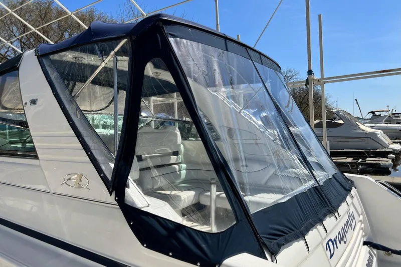 Slide: The Image of 1997 Bayliner 4085 Avanti boat with clear canopy, docked in a marina. - 44