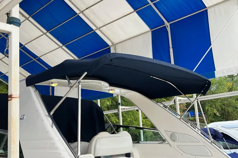 Slide: The Image of 1997 Bayliner 4085 Avanti boat with blue canopy under a blue and white shelter. - 45