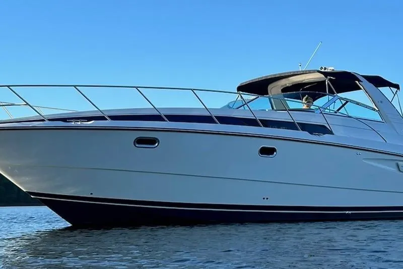Slide: The Image of 1997 Bayliner 4085 Avanti yacht on calm water under clear blue sky. - 48