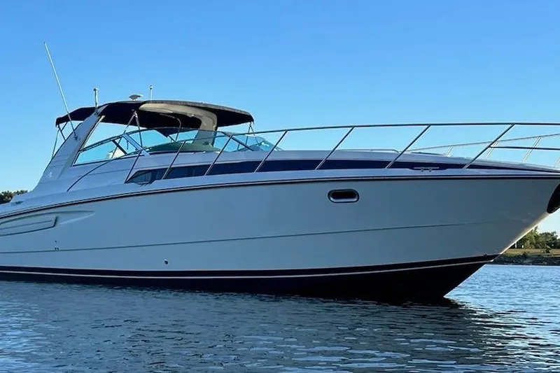 Slide: The Image of 1997 Bayliner 4085 Avanti yacht on calm water under clear blue sky. - 49