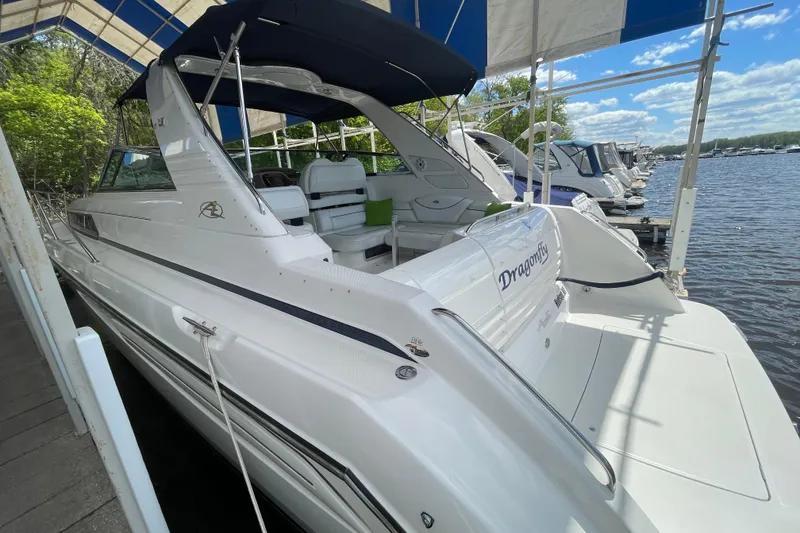 Slide: The Image of 1997 Bayliner 4085 Avanti yacht docked under canopy, featuring sleek white design. - 8