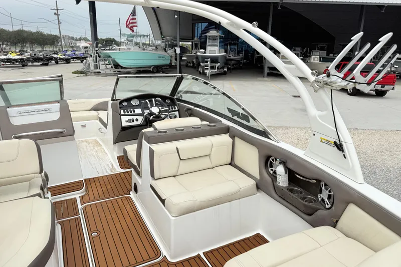 Slide: The Image of 2018 Bryant Calandra boat interior with beige seating and wooden flooring at a marina. - 13