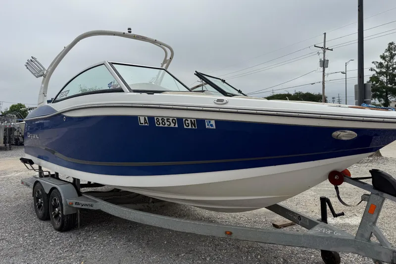 Slide: The Image of 2018 Bryant Calandra boat on trailer, blue and white design, parked outdoors. - 4