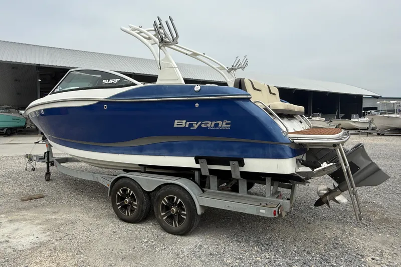 Slide: The Image of 2018 Bryant Calandra boat on trailer, blue and white, parked near storage facility. - 8
