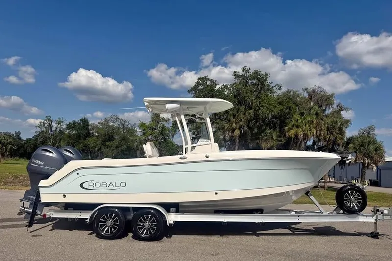 The Image of 2018 Robalo R242 Center Console boat on trailer, clear sky background. - 0