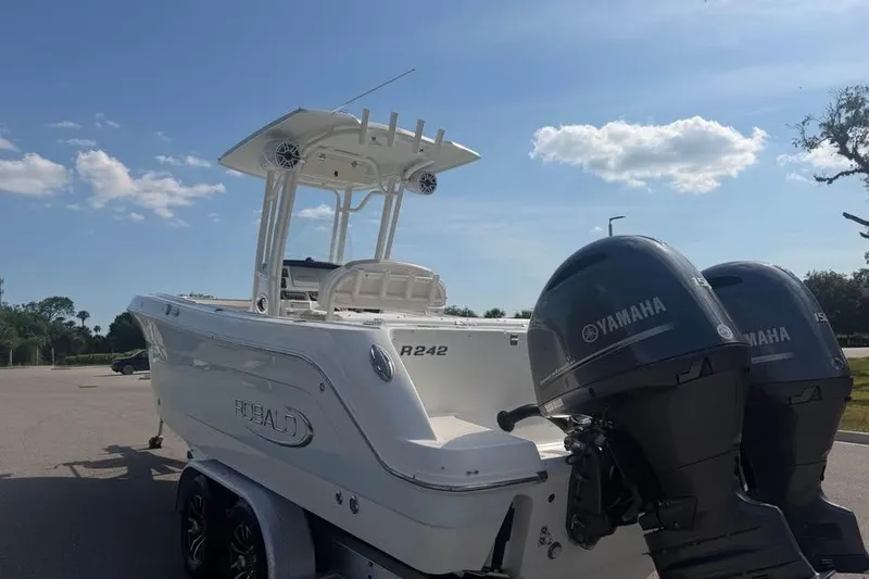 Slide: The Image of 2018 Robalo R242 Center Console boat with dual Yamaha engines on a trailer. - 11