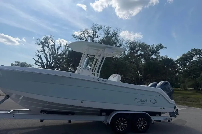 Slide: The Image of 2018 Robalo R242 Center Console boat on trailer under blue sky. - 2
