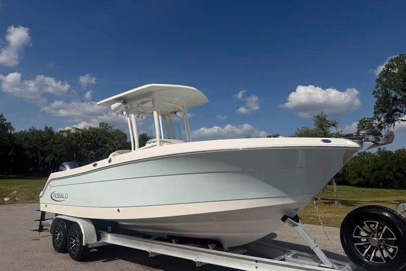 Slide: The Image of 2018 Robalo R242 Center Console boat on trailer under blue sky. - 4