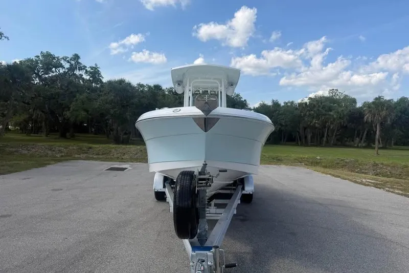 Slide: The Image of 2018 Robalo R242 Center Console boat on trailer, parked outdoors under a blue sky. - 7