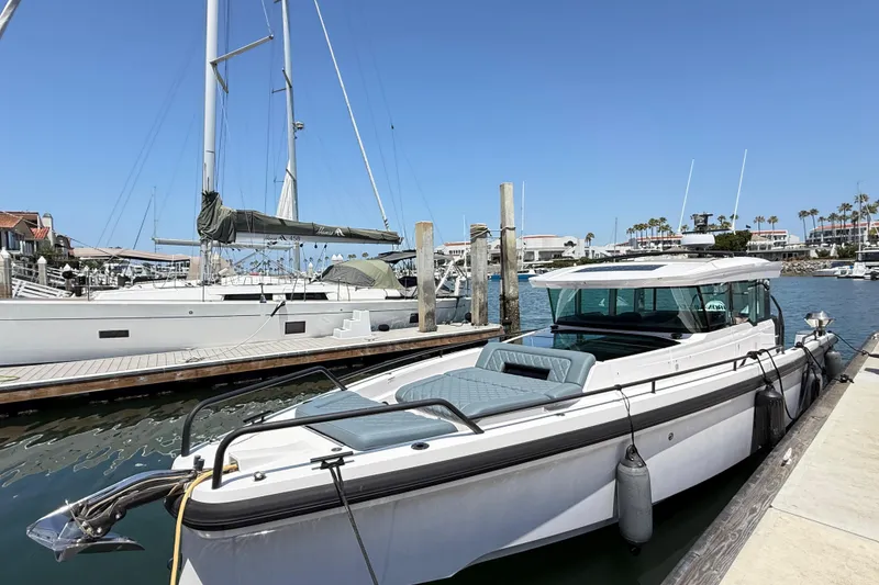 The Image of 2022 Axopar 37 XC Cross Cabin docked at a marina under clear blue skies. - 0