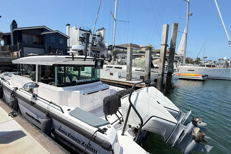 Slide: The Image of 2022 Axopar 37 XC Cross Cabin docked at a marina with modern waterfront homes. - 1