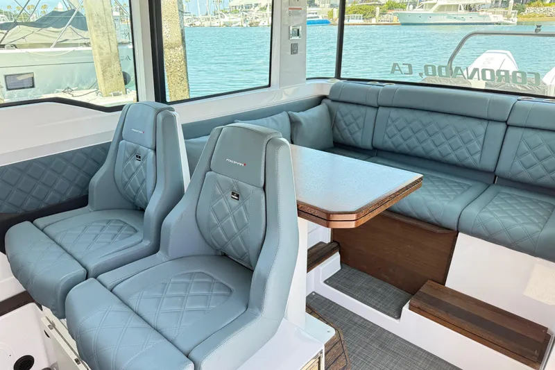 Slide: The Image of Interior of 2022 Axopar 37 XC Cross Cabin with blue quilted seating and table. - 10