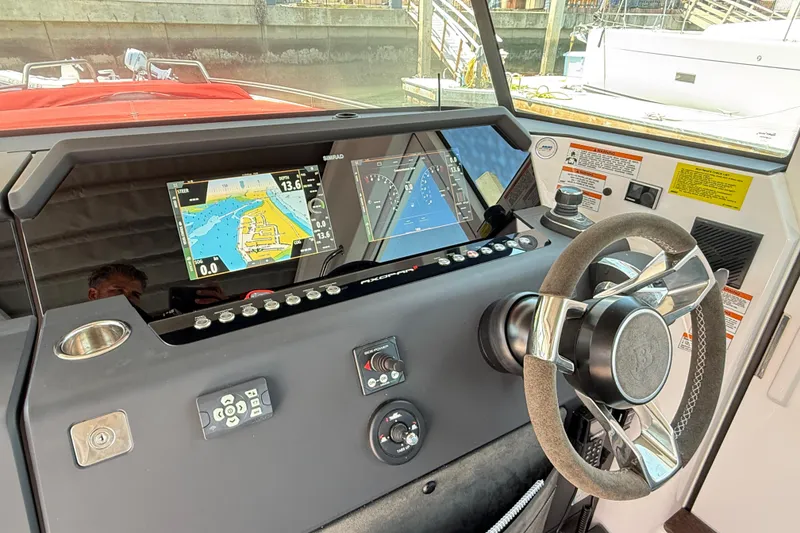 Slide: The Image of 2022 Axopar 37 XC Cross Cabin dashboard with navigation screens and steering wheel. - 13