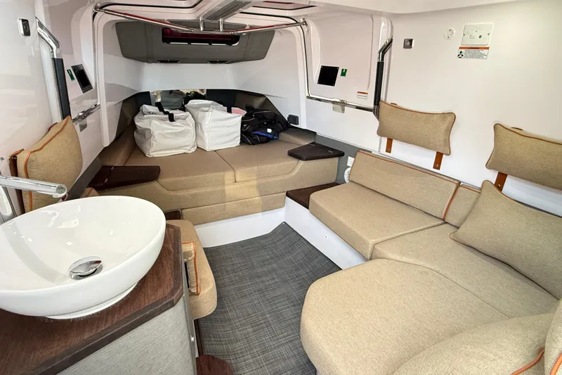 Slide: The Image of Interior of 2022 Axopar 37 XC Cross Cabin with seating, sink, and storage bags. - 23