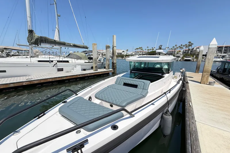 Slide: The Image of 2022 Axopar 37 XC Cross Cabin docked at marina under clear blue sky. - 3