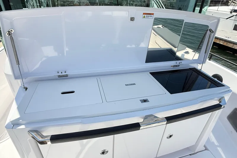 Slide: The Image of 2022 Axopar 37 XC Cross Cabin boat kitchen area with stove and storage compartments. - 9