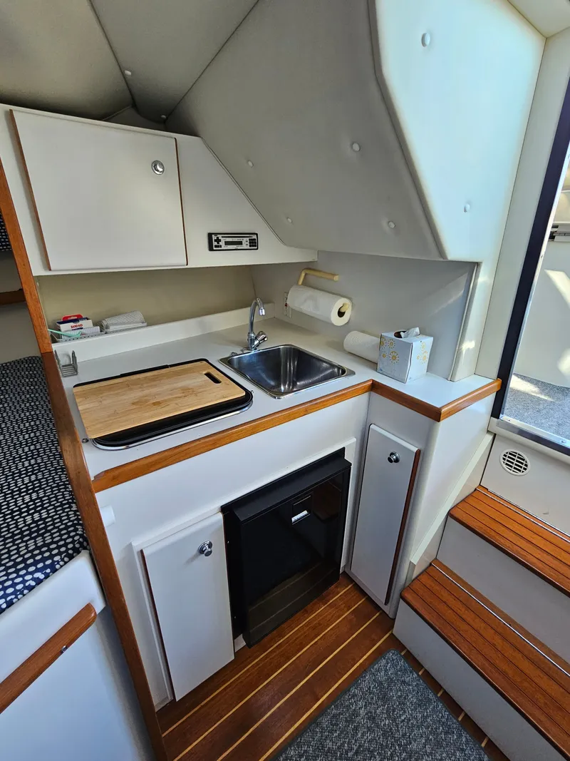 Slide: The Image of 1997 Tiara Yachts 2900 Coronet interior with kitchenette and wood accents. - 11
