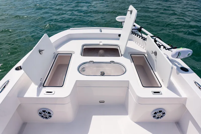 Slide: The Image of 2026 Twin Vee 22 BayCat boat deck with storage compartments and trolling motor on water. - 10