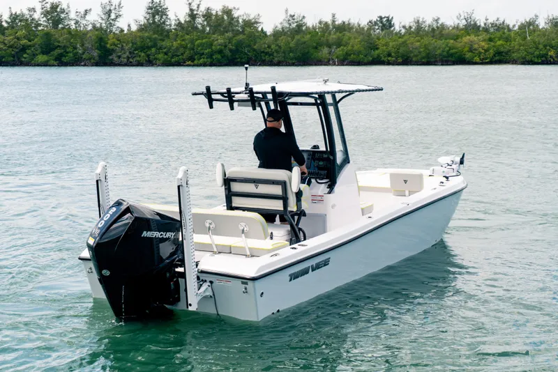 Slide: The Image of 2026 Twin Vee 22 BayCat boat on water, featuring Mercury engine, with driver navigating. - 4