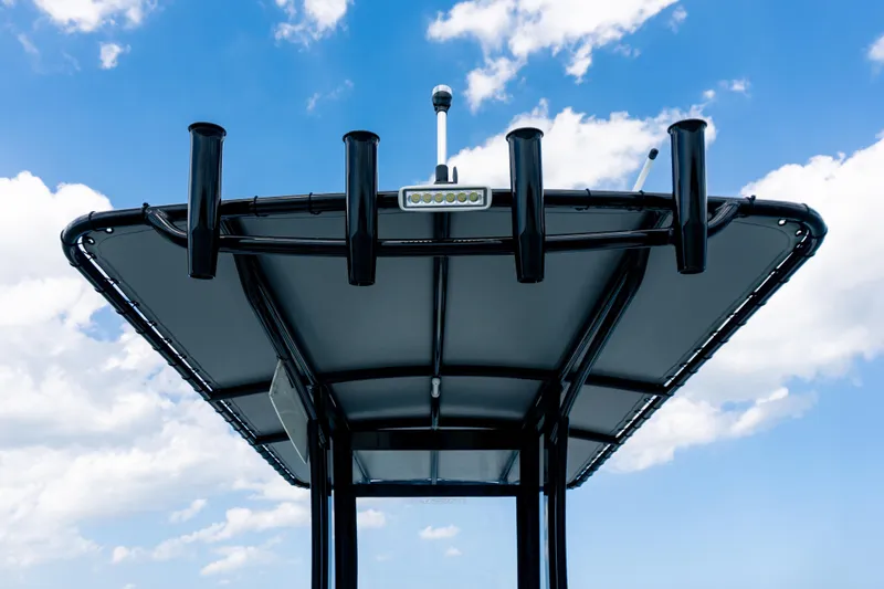 Slide: The Image of 2026 Twin Vee 22 BayCat boat canopy against a blue sky with clouds. - 8