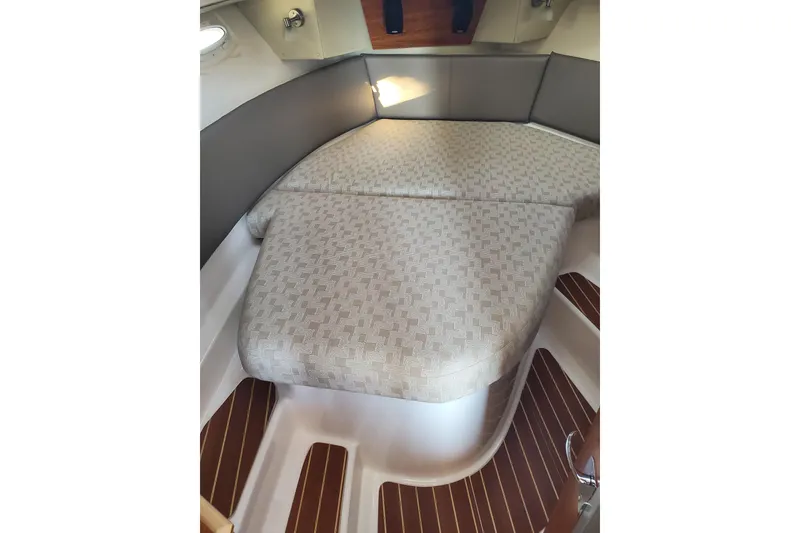 Slide: The Image of 2024 Cutwater C-30 CB cabin interior with patterned bedding and wooden flooring. - 12