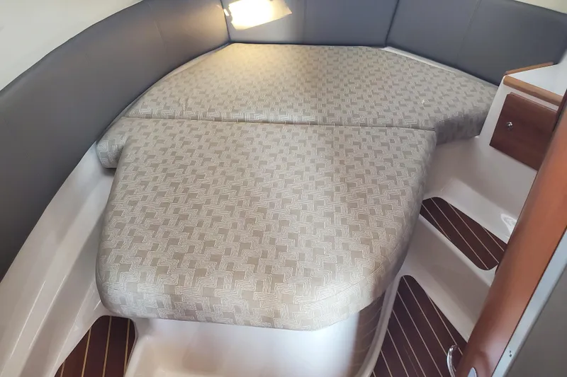 Slide: The Image of 2024 Cutwater C-30 CB cabin interior with patterned bedding and wooden accents. - 13