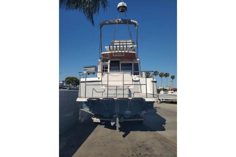 Slide: The Image of 2024 Cutwater C-30 CB boat docked, rear view under clear blue sky. - 2
