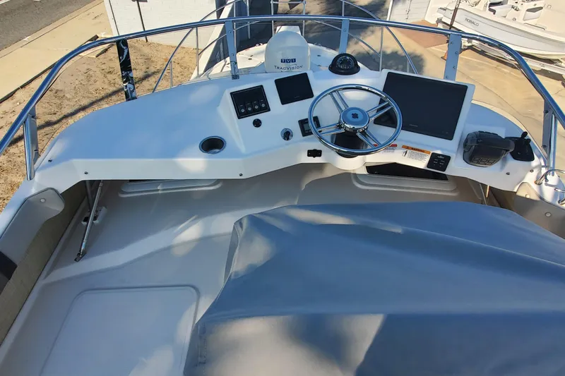 Slide: The Image of 2024 Cutwater C-30 CB boat helm with steering wheel and navigation equipment. - 23