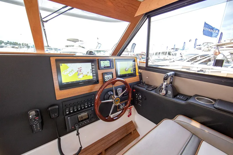 Slide: The Image of Manufacturer Provided Image: 2024 Cutwater C-30 CB boat cockpit with navigation screens and steering wheel. - 30