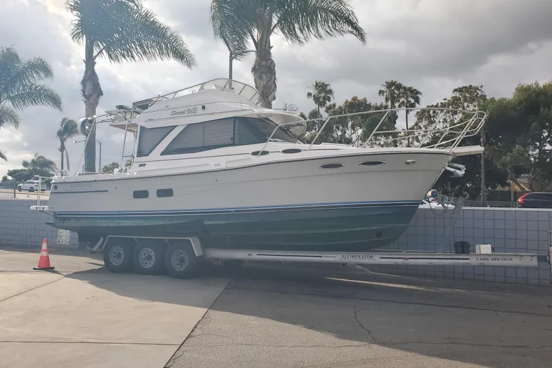 Slide: The Image of 2024 Cutwater C-30 CB boat on trailer, parked near palm trees under cloudy sky. - 38