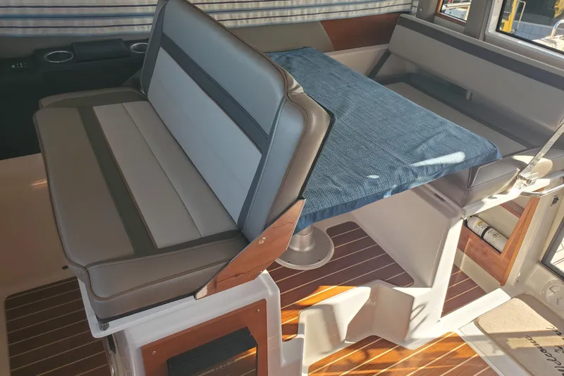 Slide: The Image of 2024 Cutwater C-30 CB interior seating with table, featuring modern design and wood accents. - 5