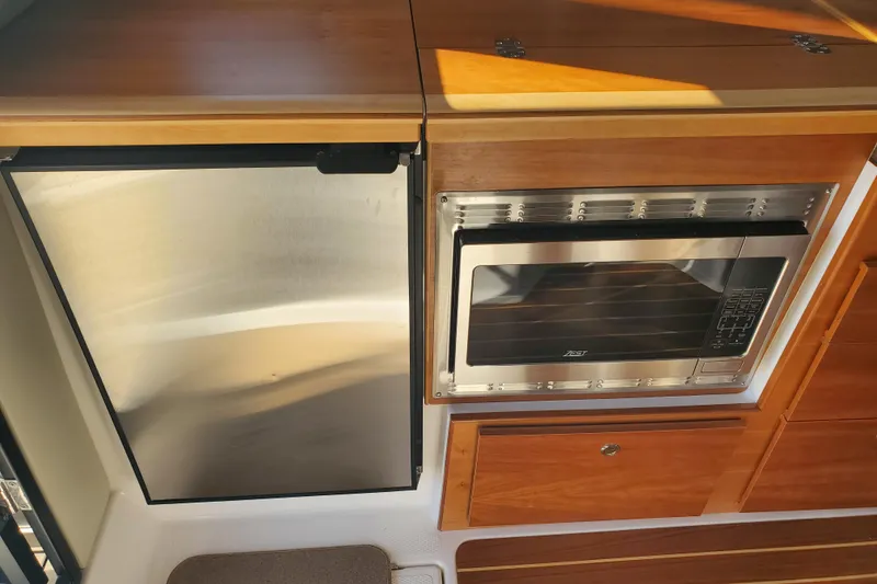 Slide: The Image of 2024 Cutwater C-30 CB interior kitchen with stainless steel fridge and microwave. - 7