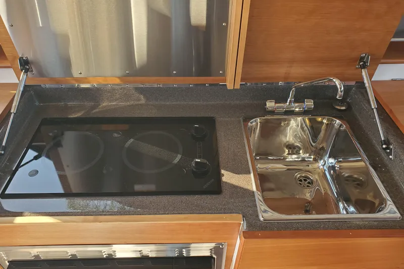 Slide: The Image of 2024 Cutwater C-30 CB kitchen with stove and stainless steel sink. - 9