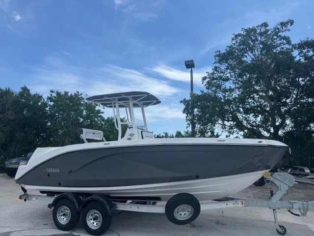 Slide: The Image of 2025 Yamaha Boats 222 FSH Sport on trailer, blue sky background. - 30
