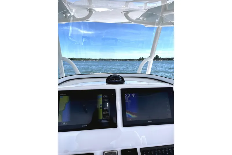 Slide: The Image of 2017 Regulator 28 Forward Seating boat dashboard with navigation screens on open water. - 3
