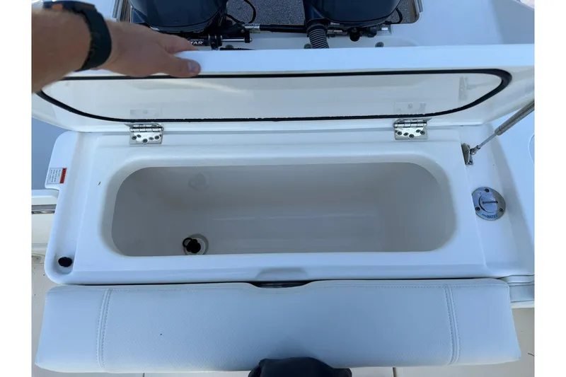 Slide: The Image of Open storage compartment on a 2021 Pursuit DC 266 Dual Console boat. - 17