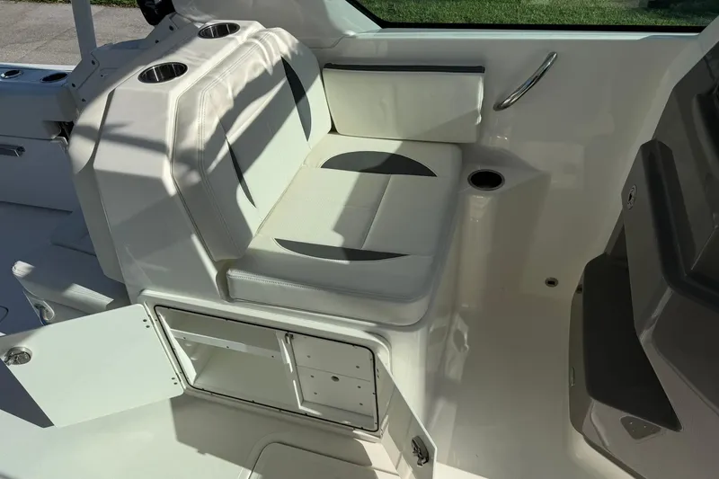 Slide: The Image of 2021 Pursuit DC 266 Dual Console interior seating with storage and cup holders. - 20