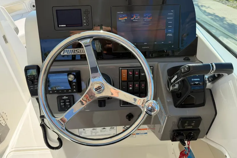 Slide: The Image of 2021 Pursuit DC 266 Dual Console dashboard with steering wheel, Garmin display, and Yamaha controls. - 23