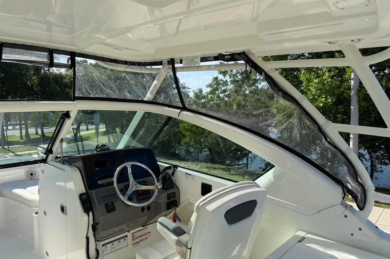 Slide: The Image of 2021 Pursuit DC 266 Dual Console boat interior with steering wheel and seating. - 25