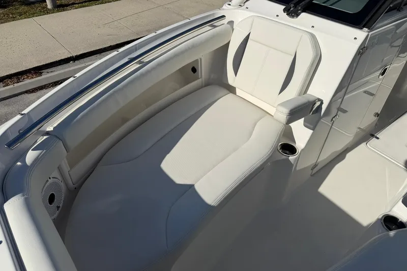 Slide: The Image of 2021 Pursuit DC 266 Dual Console boat interior with white seating and cup holders. - 32
